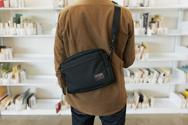 A person in a library carrying a Side Hustle